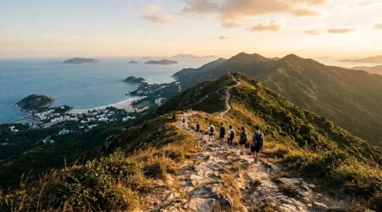 Panoramic view of Dragon's Back ridge trail with hikers on the mountain spine overlooking ocean and islands