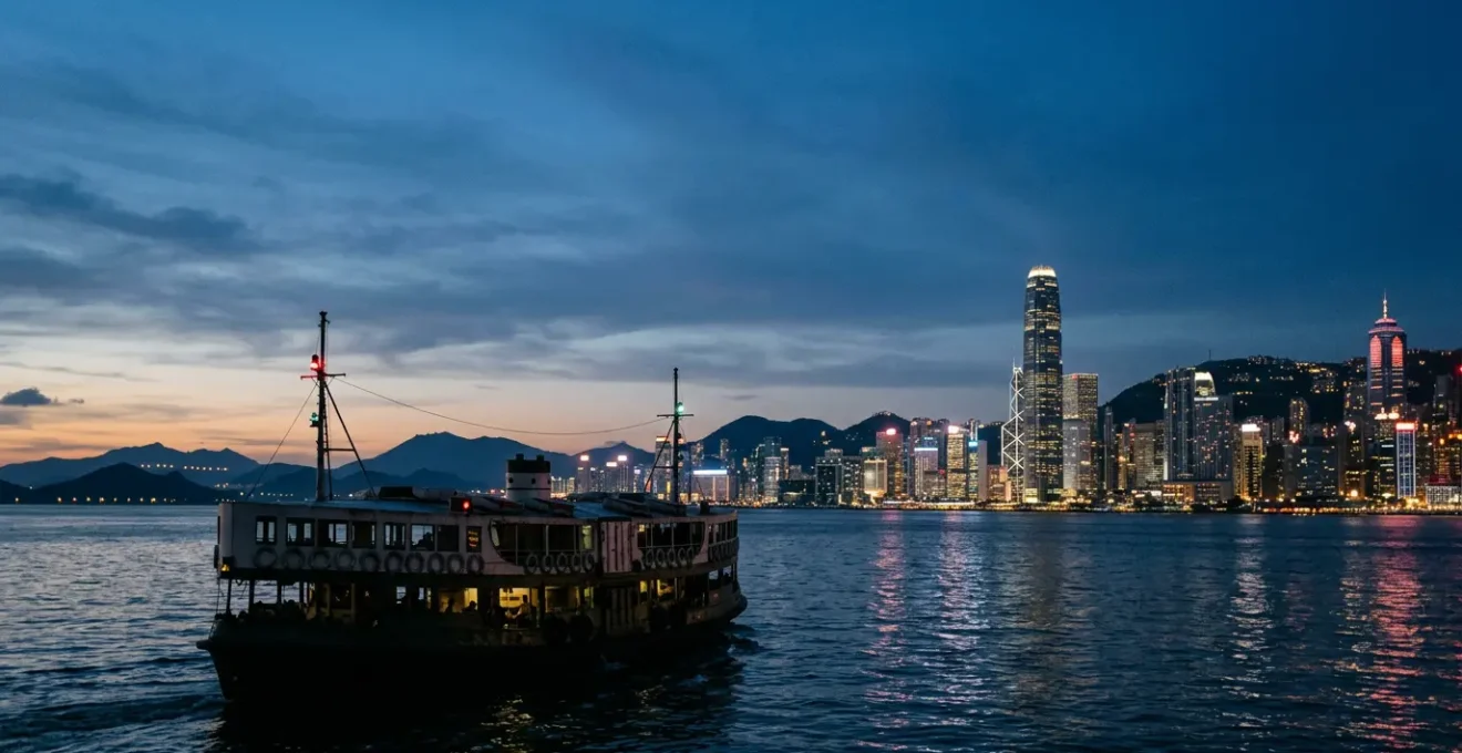 Hong Kong ferry navigating between islands at twilight with city skyline in background
