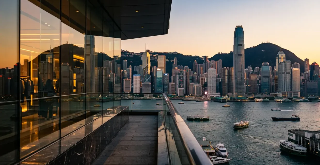 Panoramic view of Hong Kong's harbor skyline with luxury shopping districts reflecting golden light