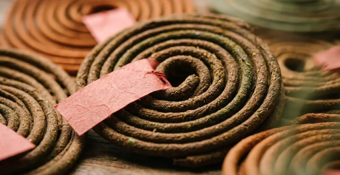Close-up macro shot of traditional red paper wishes attached to hanging incense coils