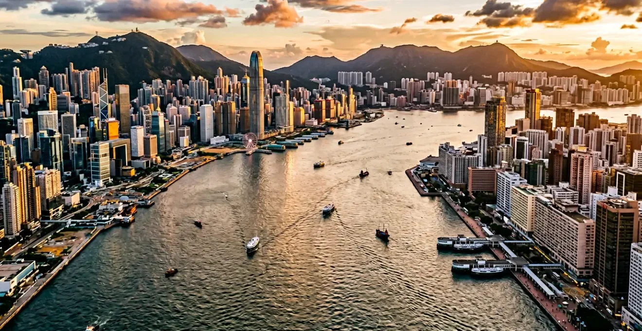 Split panoramic view of Hong Kong Island skyline and Kowloon waterfront at golden hour