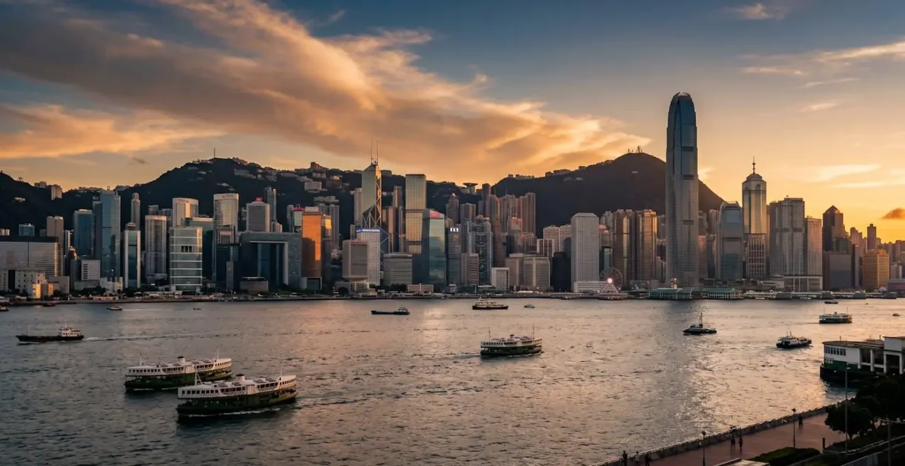 Panoramic view of Hong Kong Island skyline from Kowloon waterfront during golden hour